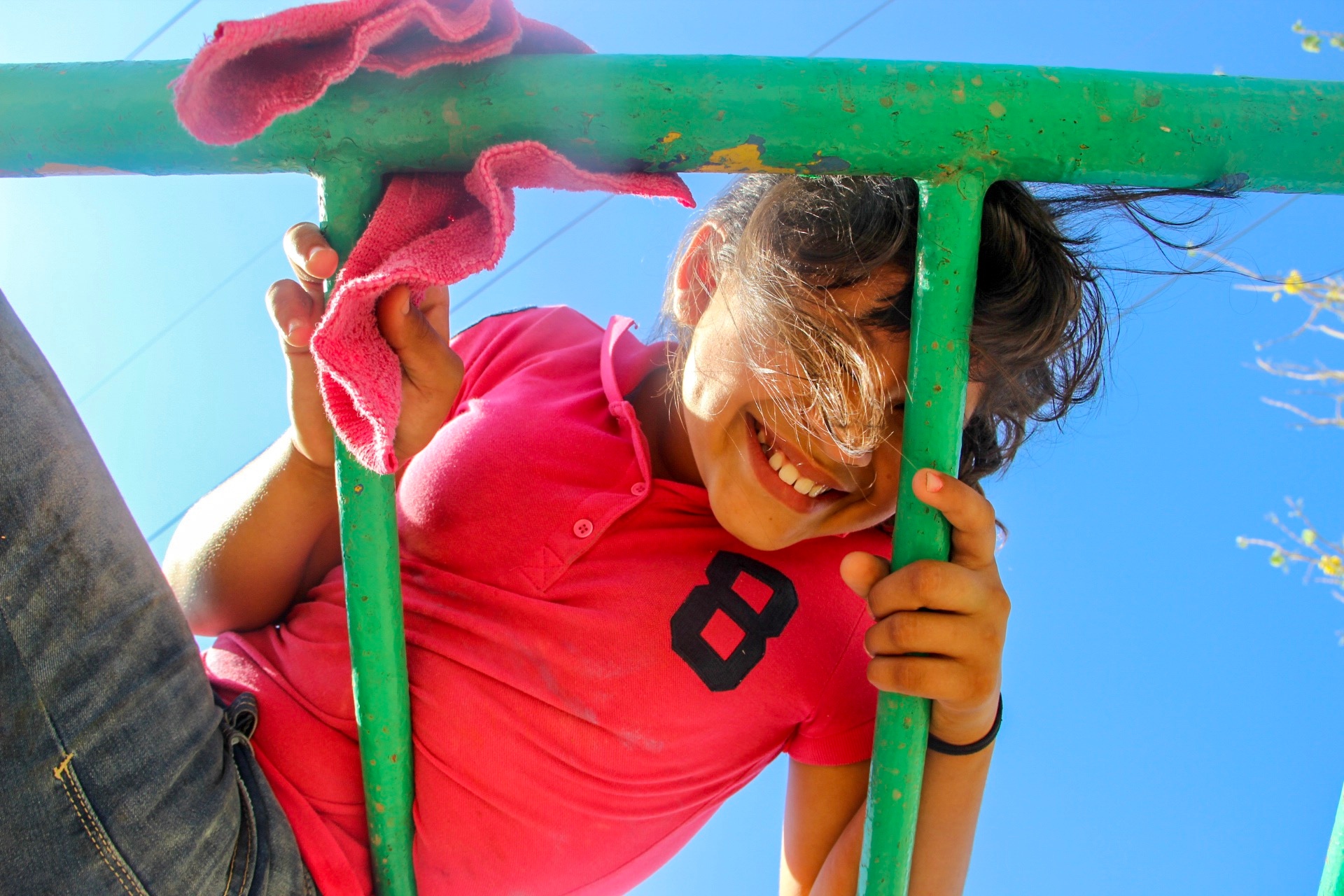 girl looking through monkey bars