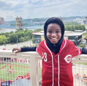 Young boy in a Cincinnati Reds jersey overlooking the city.