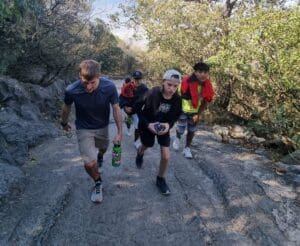 A group of 4 young men hiking up a mountain trail